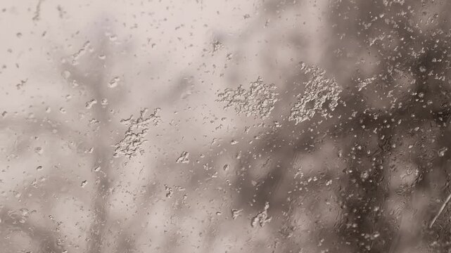 raindrops and snowflakes on glass. wet snow on glass