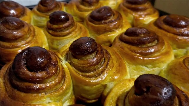 A tray of freshly baked cinnamon buns sitting on top of a table
