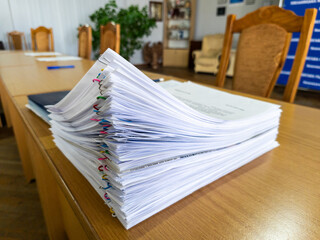 A stack of papers sitting on top of a wooden table