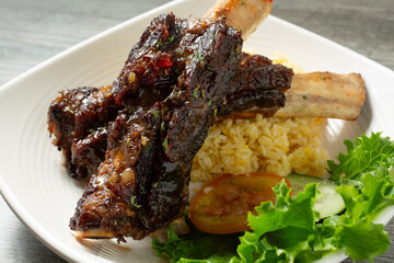 A view of a plate of BBQ beef rib with fried rice.