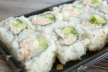 A closeup view of a tray of California roll sushi.