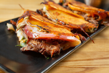 A closeup view of a plate of quesabirria tacos.
