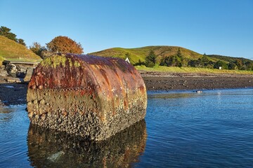 Beach campsite on an island with rusty boiler in the water