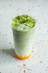 A view of a layered matcha mango milk tea.