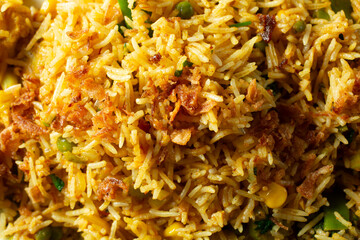 A top down view of a layer of vegetable biryani, as a background.