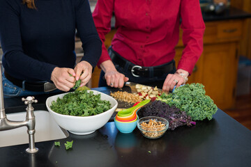 Making a Fresh Kale Salad with Apples and Walnuts Together