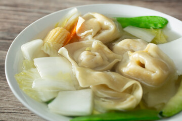 A closeup view of a bowl of wonton soup.