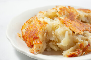 A closeup view of a plate of hash browns.