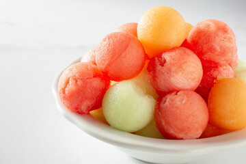 A closeup view of a bowl of melon balls.