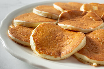 A closeup view of a plate of small pancakes.