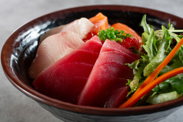 A closeup view of a bowl of chirashi sashimi.
