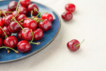 Fresh red cherries on a blue ceramic plate
