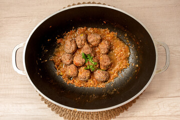 Beef meatballs in herb sauce in a cast iron skillet. Top view, homemade meatballs. Homemade.