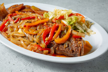 A view of a plate of brown stew fish.