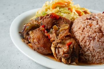 A closeup view of a plate of brown stew chicken.