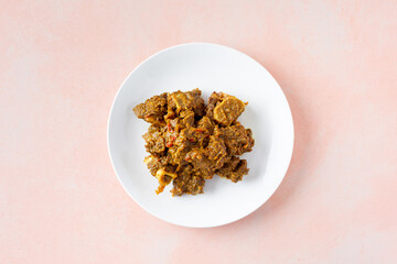 A top down view of a plate of curry goat meat.
