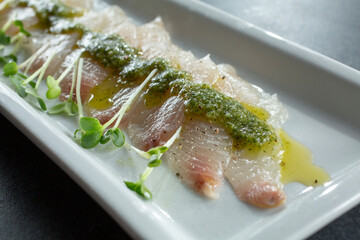 A closeup view of a plate of kanpachi carpaccio.