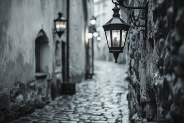 Old cobblestone street with lanterns and stone buildings in mist