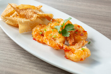 A view of a plate of garlic shrimp and fried wontons.