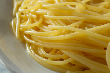 A closeup view of cooked gluten-free spaghetti, on a plate.