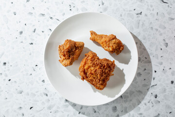 A top down view of a 3-piece fried chicken plate.