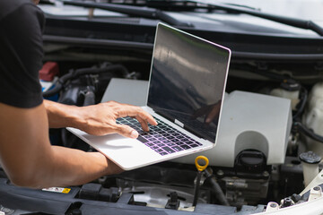 mechanic is using a computer to check the system of the control box inside the car to tune and fix car faults after checking. Concept of ​​using a computer to check read data and fix the car faults.