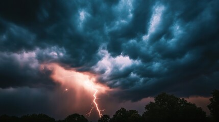 Dramatic lightning strikes through dark storm clouds during a fierce thunderstorm at twilight across a landscape.