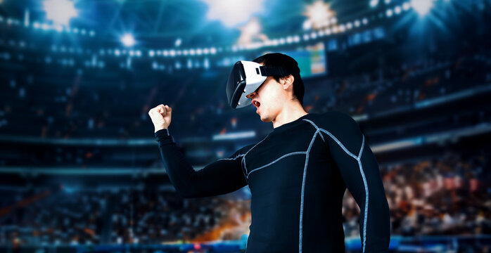Skilled gamer with VR headset celebrate his victory in video game. Professional player using augmented reality technology and winning the game while standing at stadium with inspectors. Ingenuity.