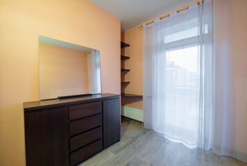Modern Bedroom Interior with a Dark Dresser and Large Glass Window