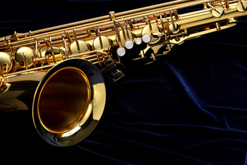 Jazz. One beautiful saxophone on dark blue fabric, closeup. Space for text