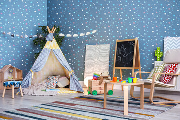 Cozy playroom with toys, furniture and cute wallpaper. Stylish children's room interior