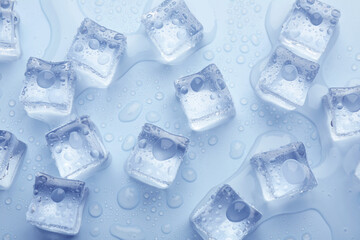 Crystal clear ice cubes on light blue background, flat lay