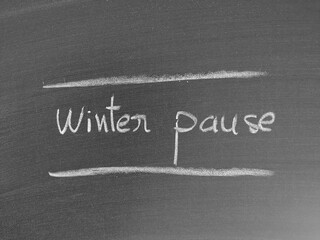 Chalkboard message displaying the words 'Winter Pause' between two horizontal lines, symbolizing a...