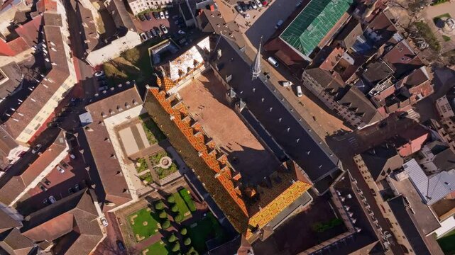 Beaune famous hospital roof glows under daylight. Aerial drone video