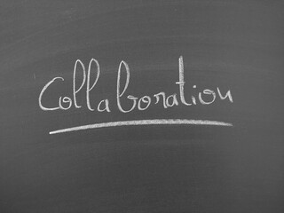 The word Collaboration is written in chalk on a chalkboard. The word is underlined with a thin chalk line for emphasis.