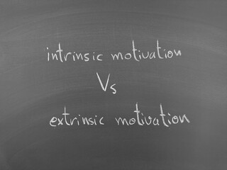 Intrinsic vs Extrinsic Motivation: A chalkboard contrasts internal drive with external rewards in motivation and behavioral science.