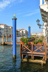 A wooden pier outside a palace overlooking the Grand Canal, the main waterway of Venice, with...