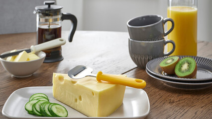 Breakfast table with cheese, cucumber, and fresh juice arranged for a delightful morning meal.