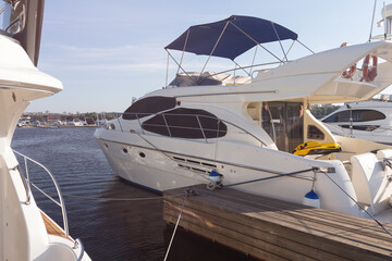Fototapeta premium Luxury yachts moored at the pier illuminated by the sun