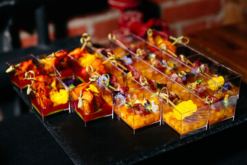 Mini seafood and mango ceviche appetizers with edible flowers.