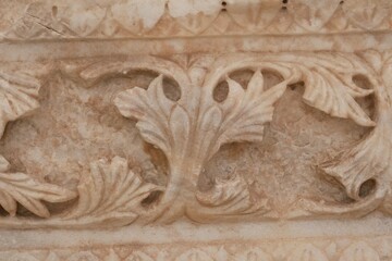 Stone carving border section in ancient city ruins. Ancient art textured background. Stone carving texture. Background for designs.Ancient stone carving, scrolls and floral patterns.