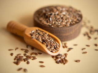 flax seeds in a wooden bowl on a beige background