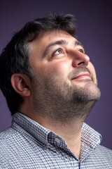 Obraz premium Conceptual art of style for aging men. Trendy men's side part haircut - midlife white man with black hair. Purple solid background. A radiant and poised man in a professional portrait.