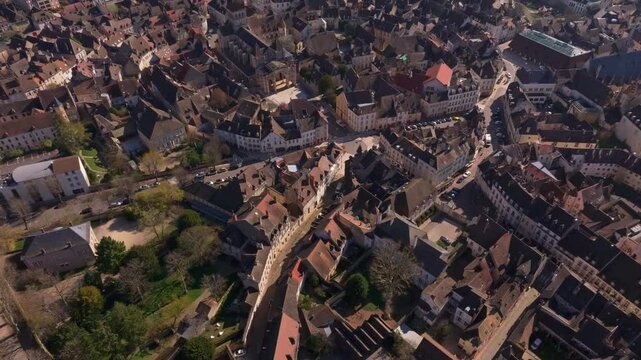 Old stone buildings fill narrow lanes in Beaune France. Aerial drone video