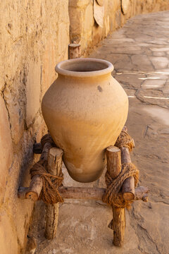 Saudi Arabia, Tabuk Province, Tayma. An amphora on a stand at a desert oasis.