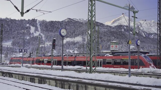Winter rail travel in Bavaria perfect way to explore alpine landscapes. Garmisch-Partenkirchen station is key hub for public transport to Germany mountains, ski resorts and cozy villages. Bahnhof. 