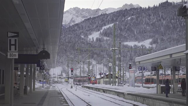 Winter rail travel in Bavaria perfect way to explore alpine landscapes. Garmisch-Partenkirchen station is key hub for public transport to Germany mountains, ski resorts and cozy villages. Bahnhof. 