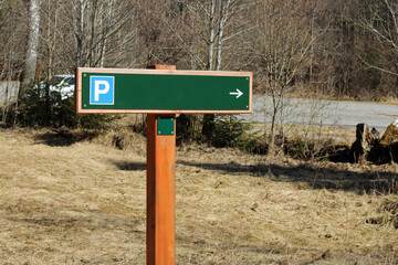A sign with a sign for a parking lot in the countryside by the forest