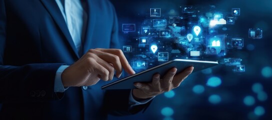 Person in suit using tablet with glowing network icons in blue light.