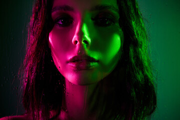 Portrait of a passionate woman illuminated by vibrant pink and green neon lighting capturing expressive modern club